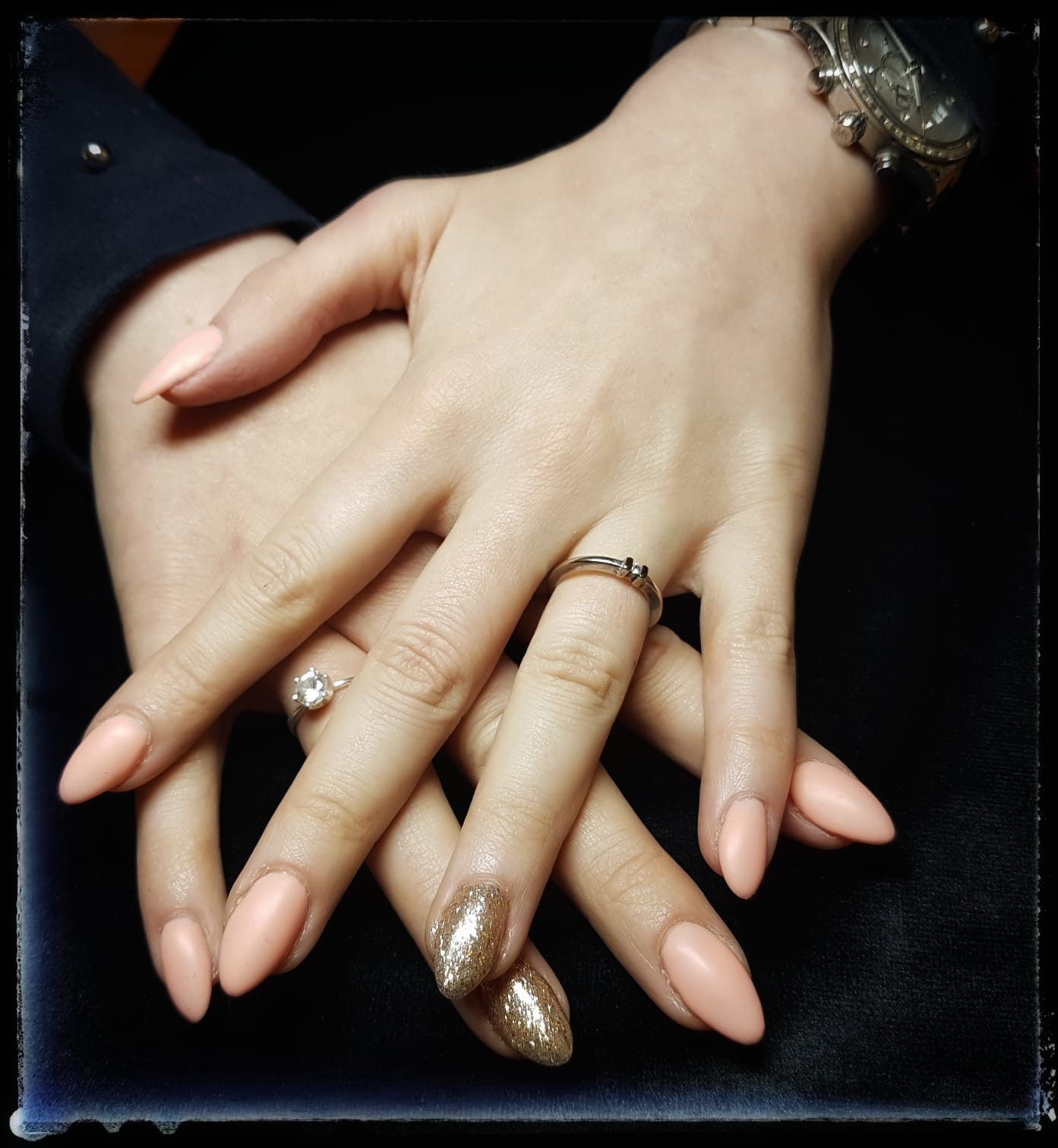 Perzikkleurige amandelvormige nagels met een gouden glitteraccent