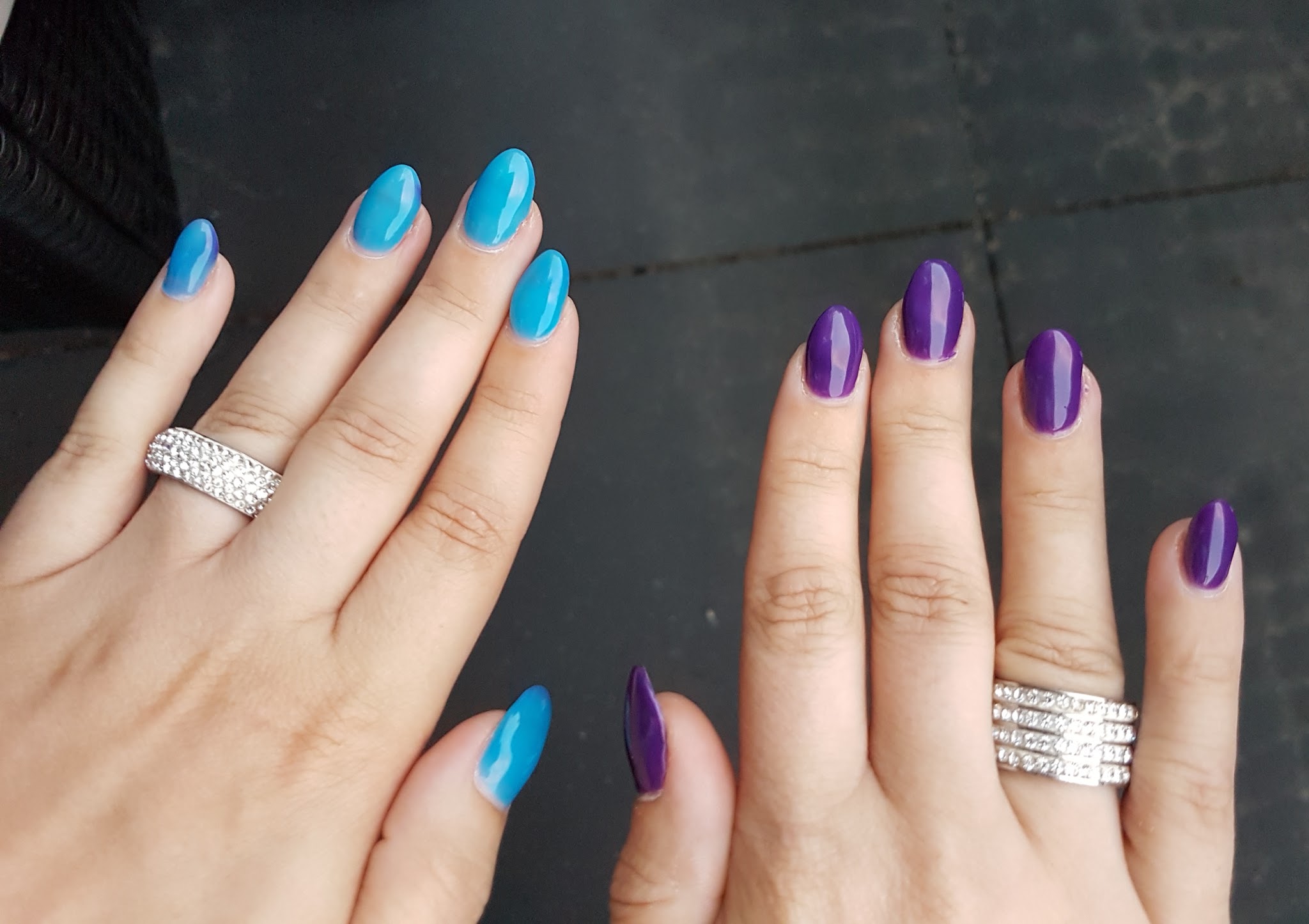 Twee handen met turquoise en paarse gellac
